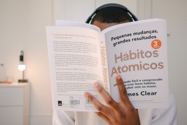a man reading a book with headphones on his head — Foto por Nubelson Fernandes na Unsplash