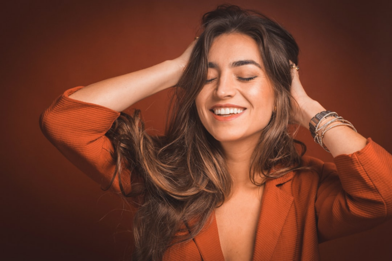 smiling woman in brown top holding hairs — Foto por Pablo Merchán Montes na Unsplash
